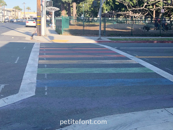 Sidewalk with rainbow colored stripes as seen in Alamitos Beach, Long Beach