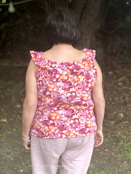 Woman modeling a sleeveless floral gauze version of New Look Patterns 6892 view E blouse from the back
