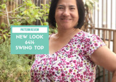 A woman with short black hair has her left hand on her hip and a big smile on her face, with a green text box next to her that reads "pattern review new look 6414 swing top" and a web address at the bottom of petite font dot com.