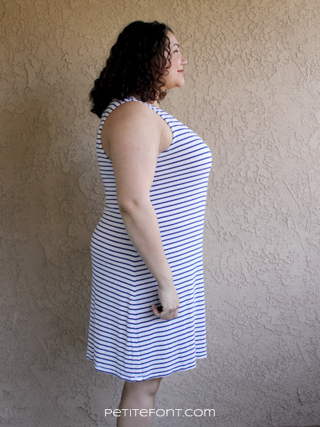 Side view of curly haired brunette in a striped blue and white knit tank dress based on McCall's 6744 pattern. Text at bottom reads petite font dot com.