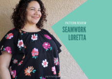 Curly haired brunette leaning against a stucco wall wearing a handmade Seamwork Loretta in black floral cotton gauze with green box and text overlay that reads Pattern Review Seamwork Loretta. Web address petite font dot com.