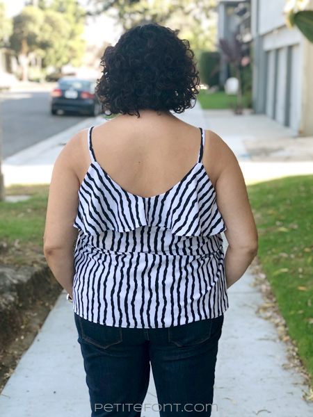 Back view of a curly haired Latina woman in a striped ruffled Ogden cami hack