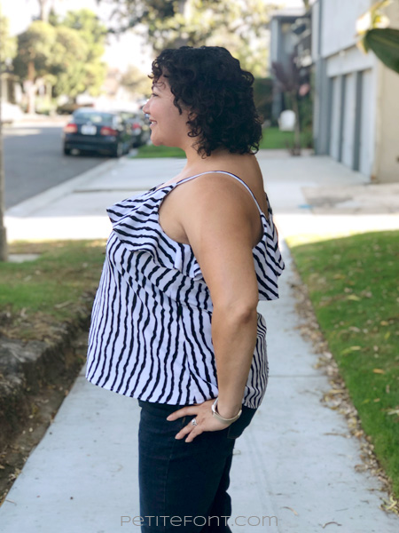 Side view of a curly haired Latina woman in a striped ruffled Ogden cami hack