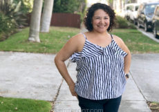 Curly haired Latina woman in a striped ruffled Ogden cami hack facing camera