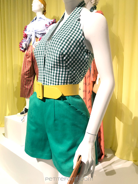 Close up shot of mannequin wearing green scalloped shorts, green gingham halter top, and yellow belt from the Amazon Prime show The Marvelous Mrs. Maisel, from FIDM 13th Art of Television Costume Design exhibit