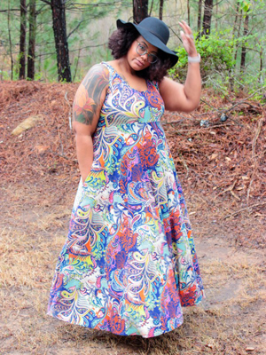 Blogger Aaronica in a sleeveless floral dress and black hat