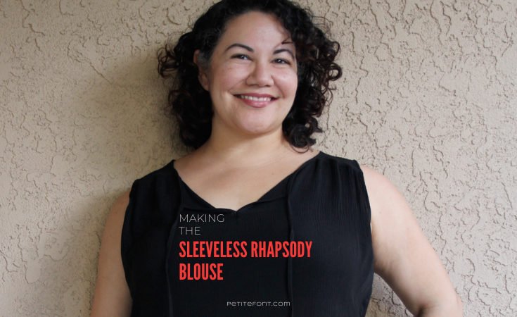 Curly haired Latina woman leaning against beige stucco wall with text overlay that reads Making the Sleeveless Rhapsody Blouse petite font dot com