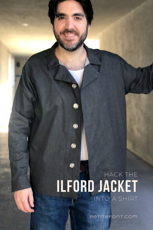 Dark haired man wearing an open front dark charcoal grey Ilford jacket as a shirt, with jeans. Text overlay reads Hack the Ilford Jacket into a Shirt, PetiteFont.com