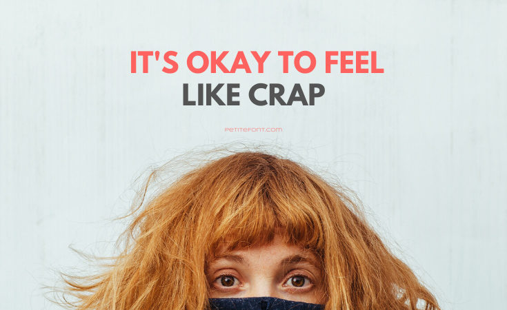 Top of a redheaded woman's face hiding in a black sweater with text above that reads It's Okay to Feel Like Crap PetiteFont.com
