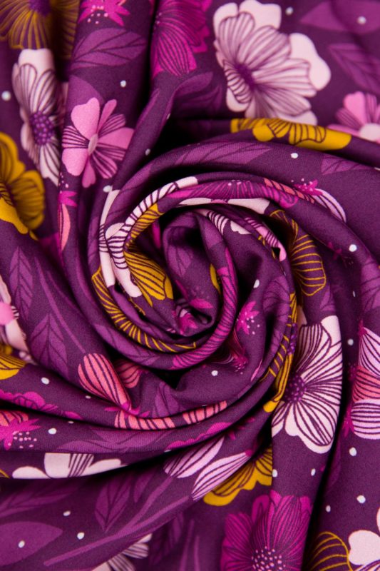 Close up view of Figo rayon fabric in Sangria floral print rolled up