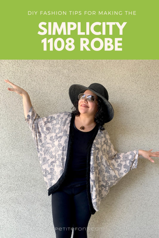 A picture of a woman in a hat and sunglasses, leaning against a light stucco wall. Her arms are out like a bird as she looks up. She has a fringed peach and black paisley robe on over an all black outfit. Text overlay reads "DIY Fashion Tips for Making the Simplicity 1108 Robe."