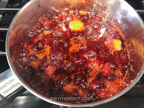 Strawberries, figs, chipotles, and lemon rind simmering on the stovetop