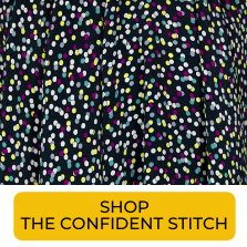 Swatch of multicolored polka dots on dark background fabric from The Confident Stitch